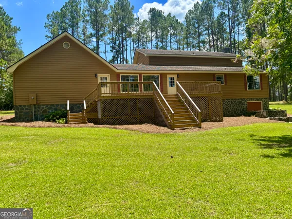 a view of an house with backyard and a tree