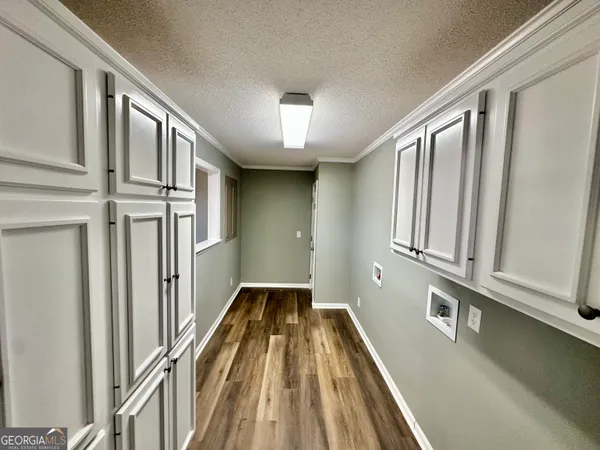 a view of a hallway with wooden floor and staircase