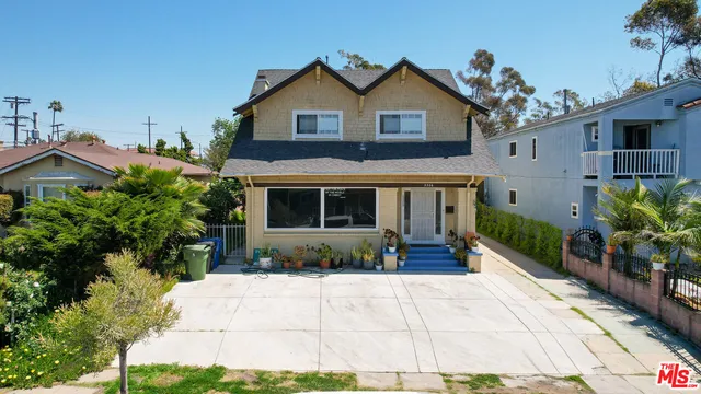 a front view of a house with a yard and potted plants