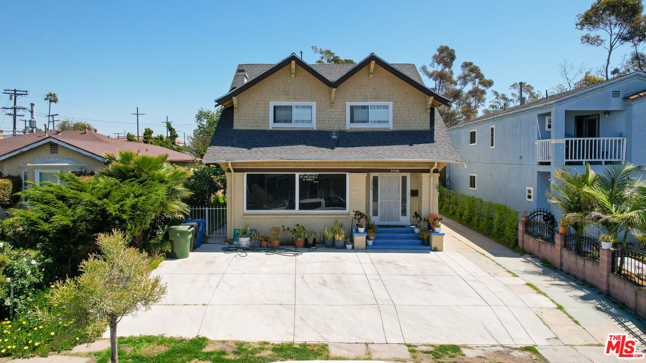 a front view of a house with a yard and potted plants