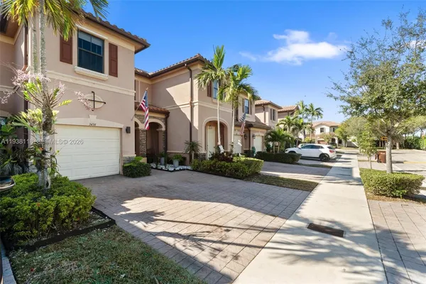 a front view of a house with a yard and trees