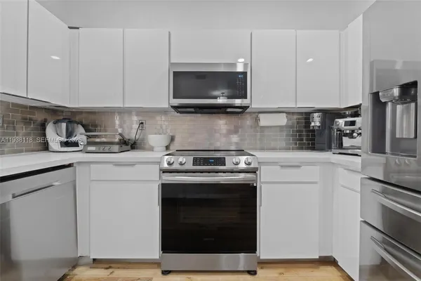 a kitchen with stainless steel appliances granite countertop a stove a microwave and cabinets