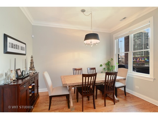 220 North Halsted Street, Unit 2 Chicago, IL 60661 - Photo 6 of 13 a view of a dining room and livingroom with furniture wooden floor and a chandelier
