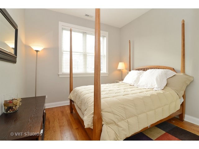 220 North Halsted Street, Unit 2 Chicago, IL 60661 - Photo 10 of 13 a bedroom with a bed and a night stand