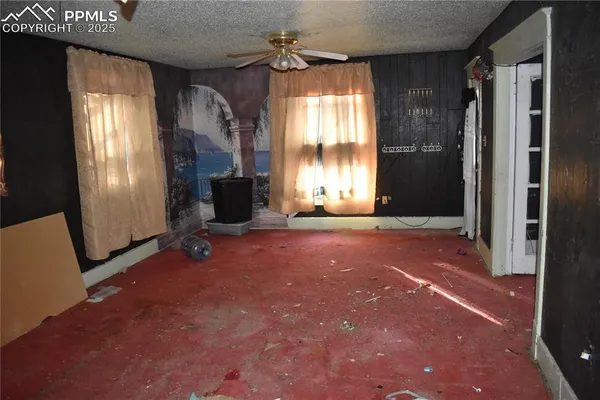 a view of an empty room with a fireplace and a window