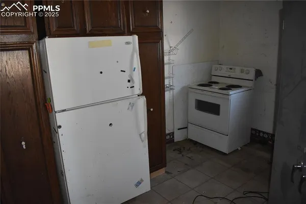 a white refrigerator freezer and a stove sitting inside of a kitchen