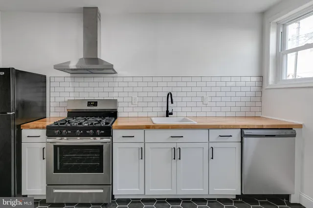 a kitchen with granite countertop a stove sink and cabinets