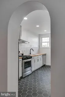 a large white kitchen with sink stove and refrigerator