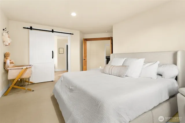 a bedroom with a bed and a flat tv screen next to a window