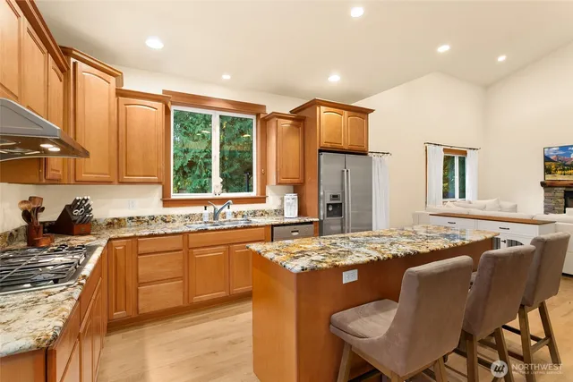 a kitchen with kitchen island granite countertop a sink and stove