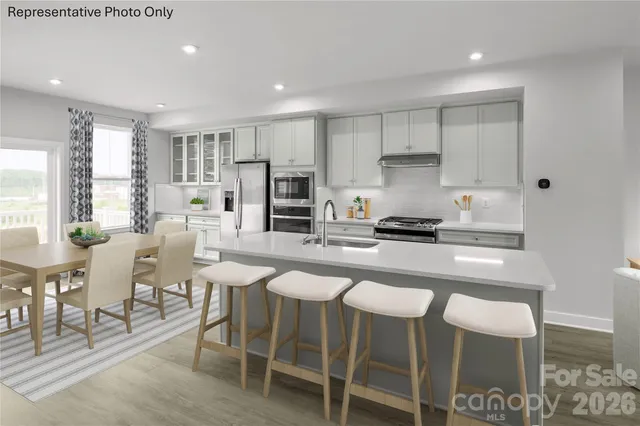 a kitchen with stainless steel appliances granite countertop a table and chairs