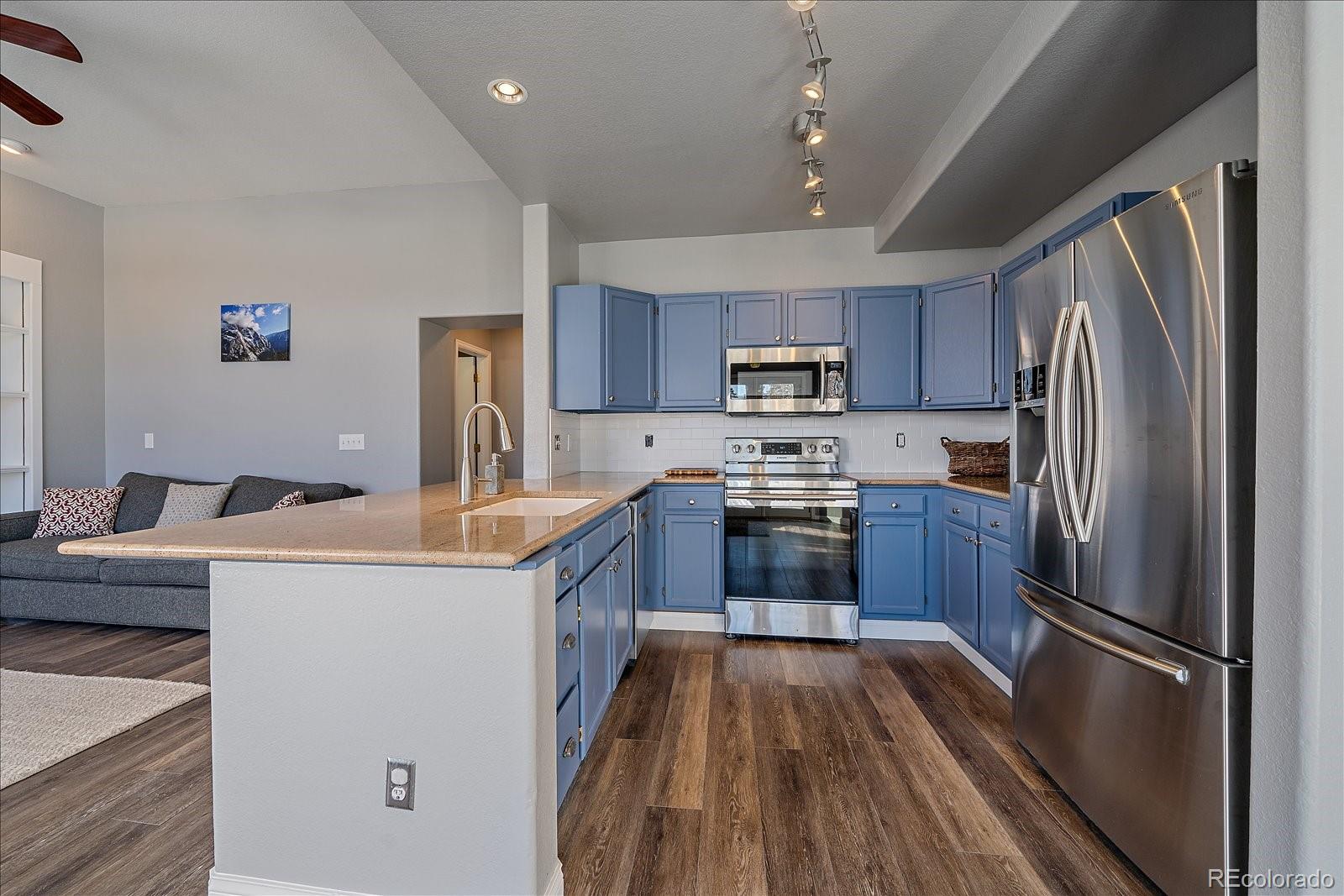 722 Calgary Way Golden, CO 80401 - Photo 16 of 50 a kitchen with kitchen island a counter top space a sink and stainless steel appliances