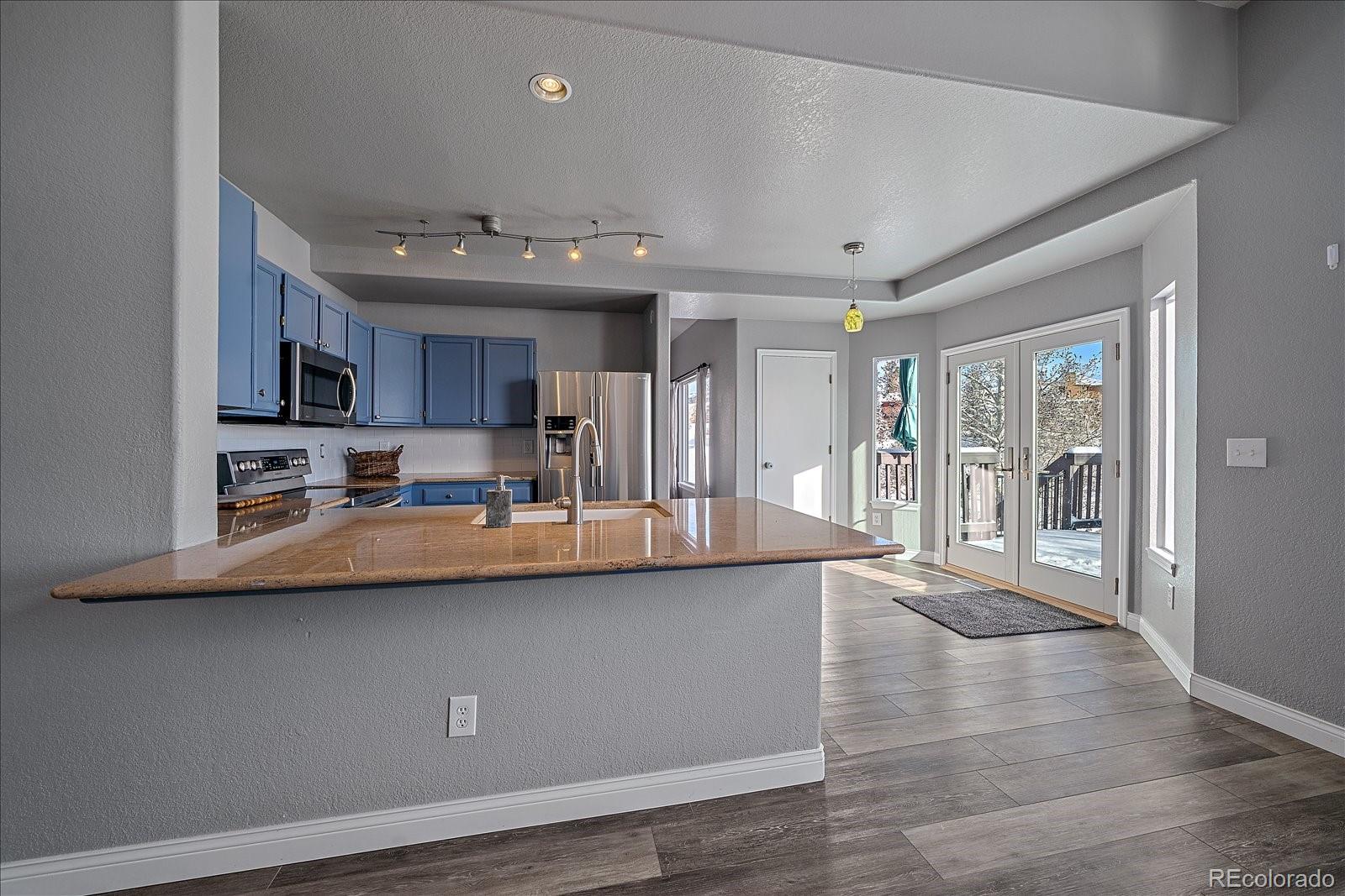 722 Calgary Way Golden, CO 80401 - Photo 17 of 50 a kitchen with stainless steel appliances granite countertop a sink a stove and a refrigerator