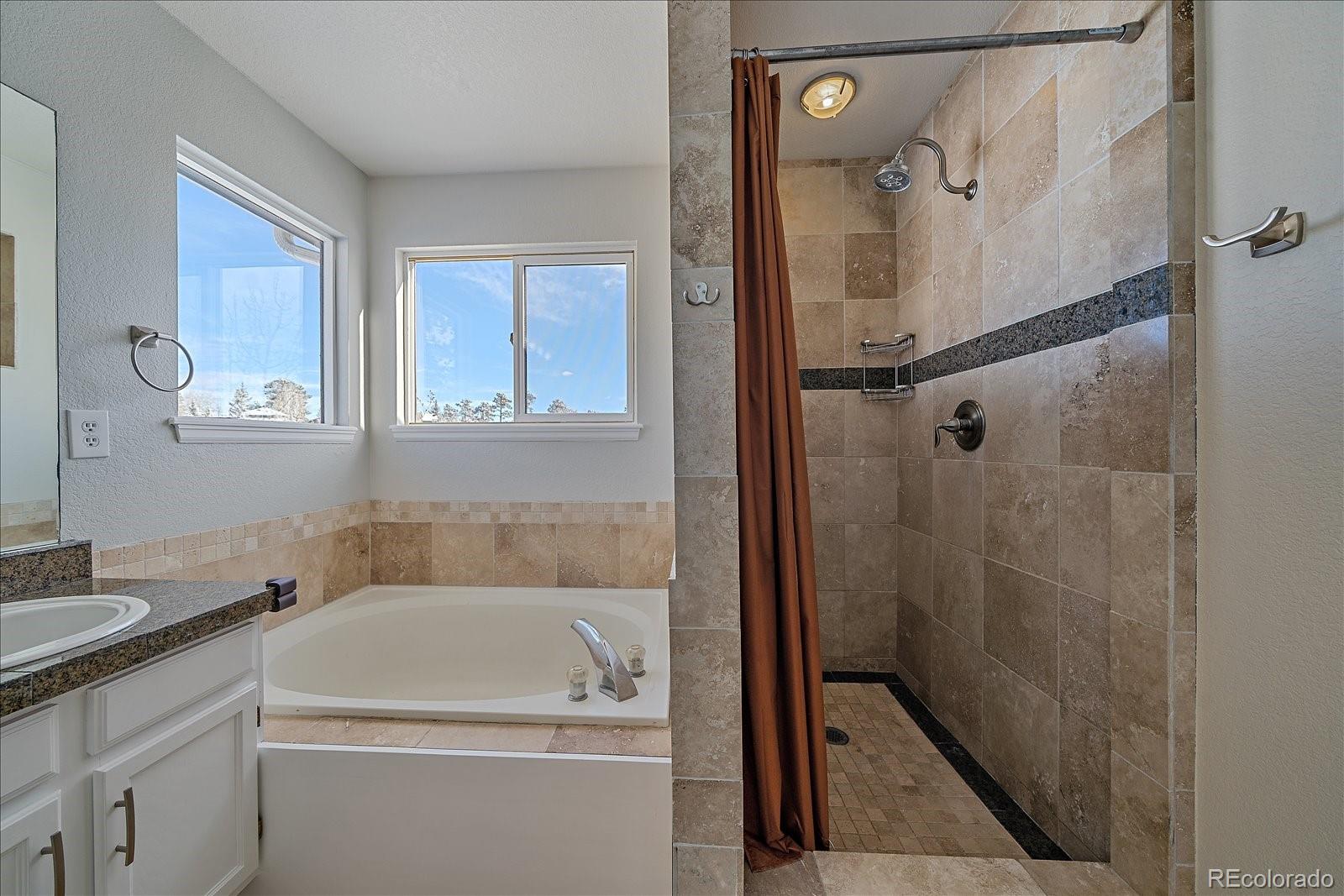 722 Calgary Way Golden, CO 80401 - Photo 27 of 50 a bathroom with a sink a mirror and a shower