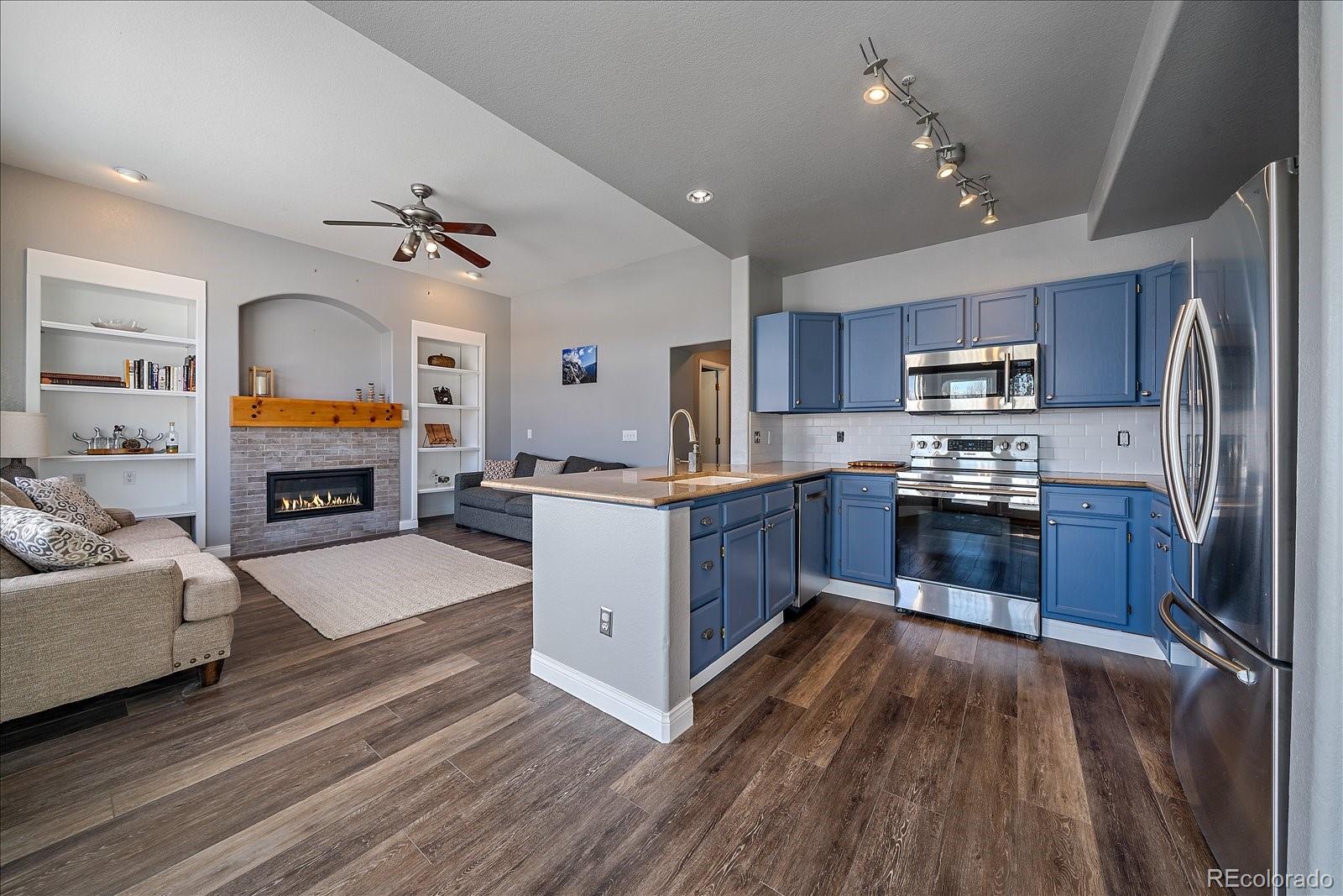 722 Calgary Way Golden, CO 80401 - Photo 7 of 50 a kitchen with stainless steel appliances granite countertop a refrigerator a stove top oven a sink dishwasher and wooden cabinets with wooden floor