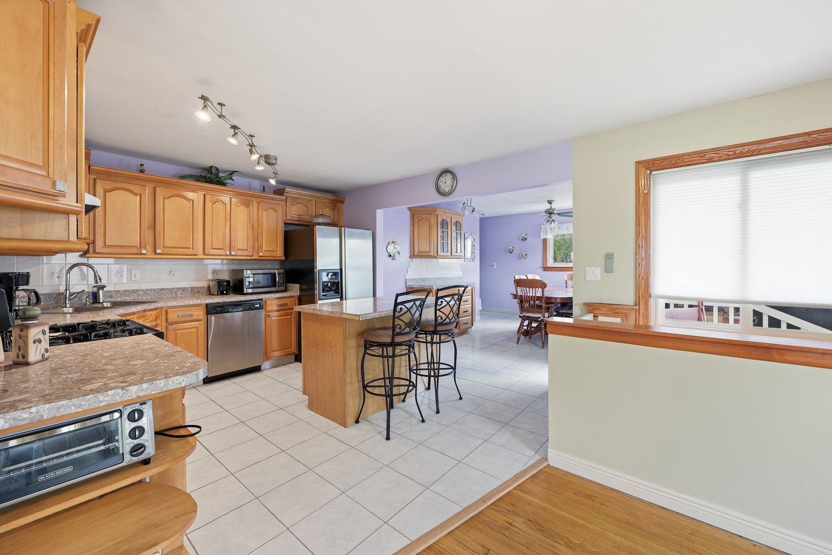 329 East Myrick Avenue Addison, IL 60101 - Photo 5 of 30 a kitchen with stainless steel appliances kitchen island granite countertop a refrigerator a stove a sink a dining table and chairs with wooden floor