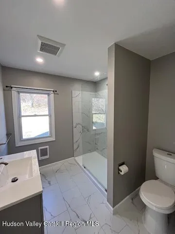 a bathroom with a sink a toilet and a mirror