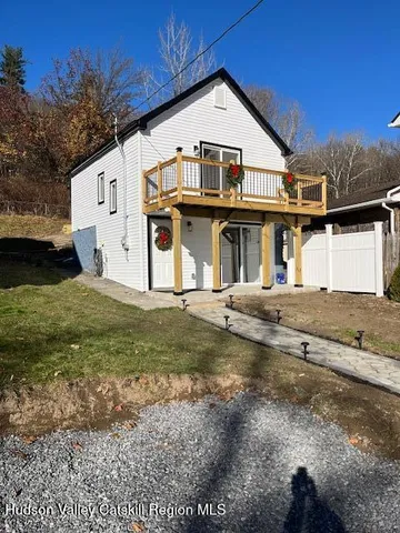 a view of a big house with a big yard and large tree