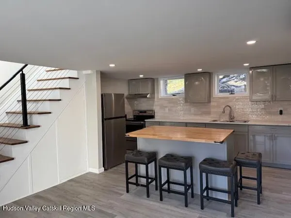 a kitchen with stainless steel appliances granite countertop a table chairs sink and cabinets