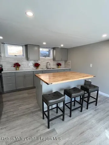 a kitchen with stainless steel appliances kitchen island granite countertop a table chairs sink and cabinets