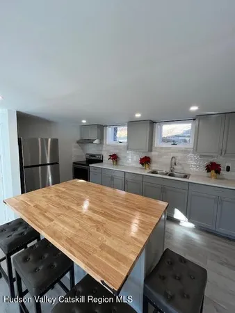 a open kitchen with stainless steel appliances granite countertop a stove refrigerator and wooden cabinets