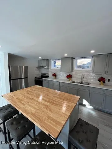 a open kitchen with stainless steel appliances granite countertop a stove refrigerator and wooden cabinets