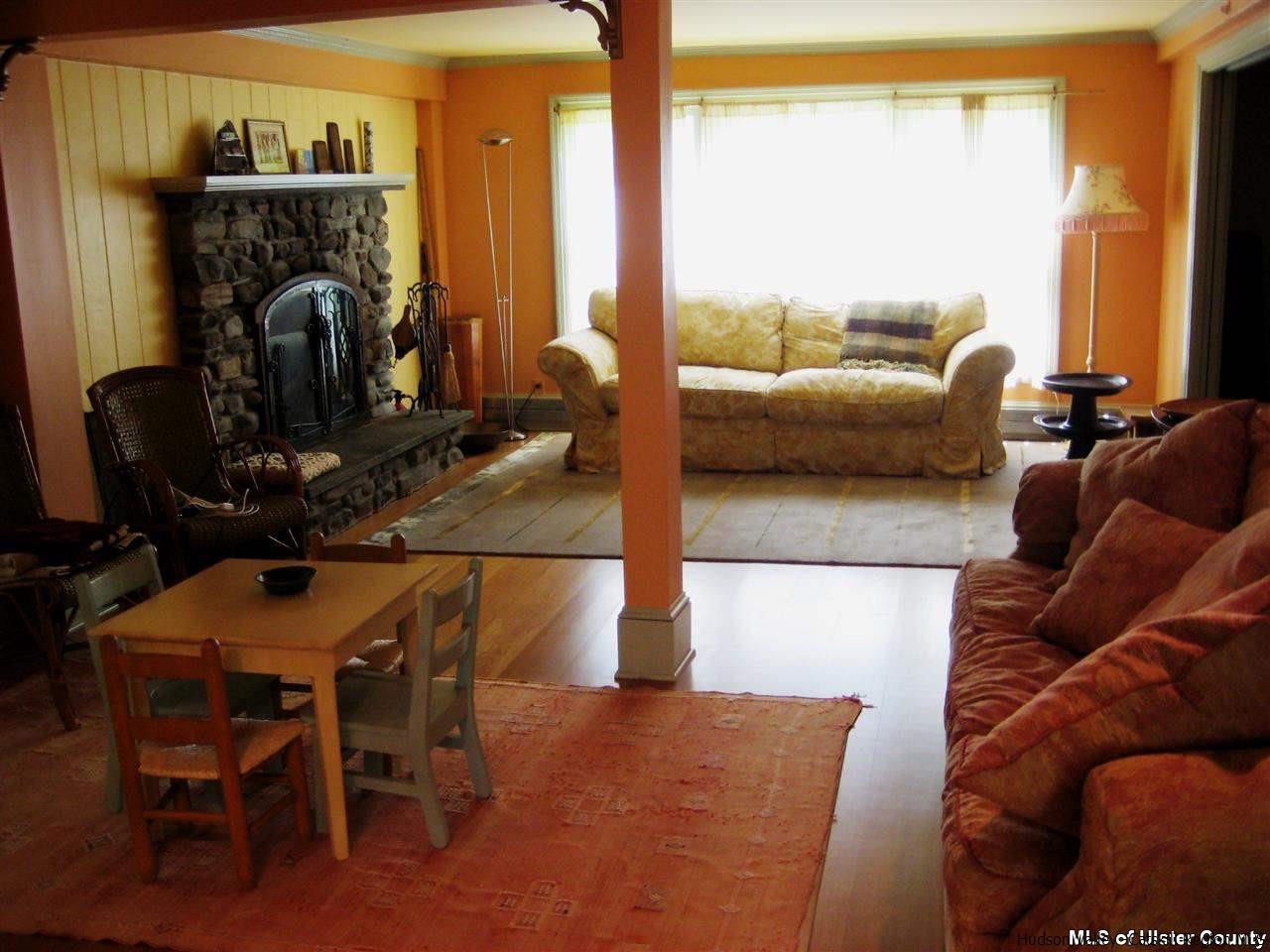 17 Cross Patch Road Woodstock, NY 12495 - Photo 11 of 35 a living room with furniture a floor to ceiling window and a fireplace