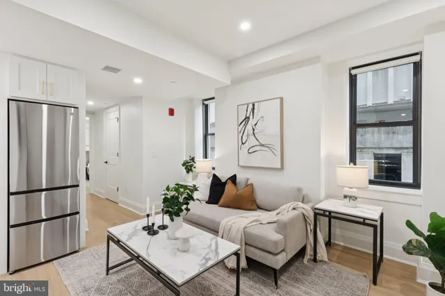 a living room with furniture a large window and a table