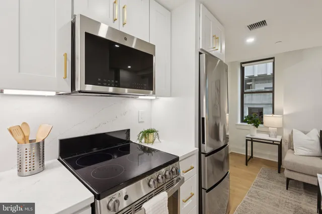 a kitchen with stainless steel appliances granite countertop a stove a microwave and a refrigerator