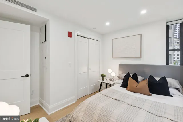 a bedroom with a bed and a wooden floor