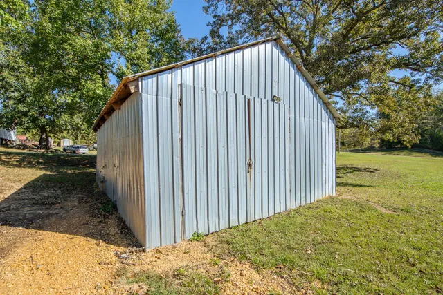 a view of a small house with yard and sitting area