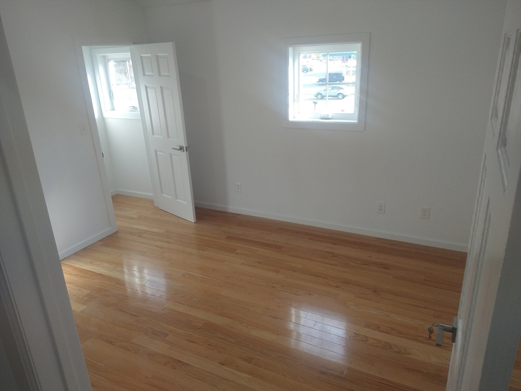 26 Russell Street, Unit AB Hadley, MA 01035 - Photo 19 of 42 a view of an empty room with wooden floor and a window