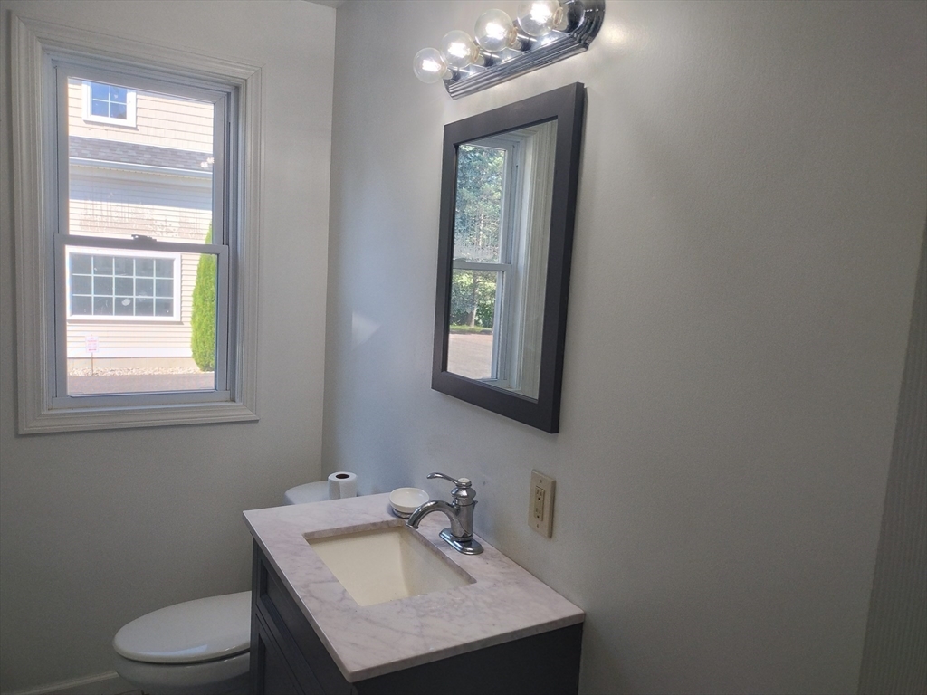 26 Russell Street, Unit AB Hadley, MA 01035 - Photo 36 of 42 a bathroom with a toilet sink and mirror