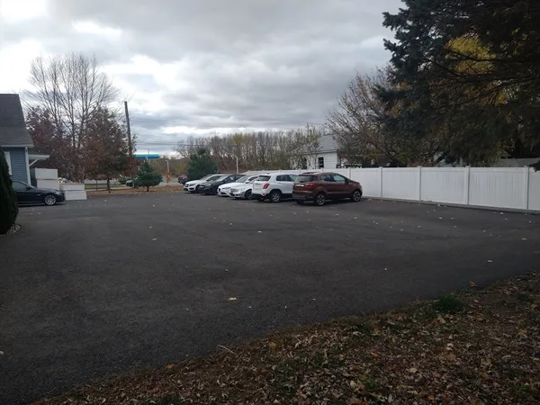 a view of a white house next to a yard
