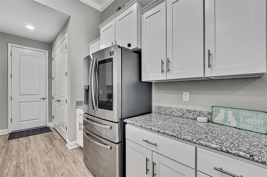 9504 Earthwind Court Weeki Wachee, FL 34613 - Photo 13 of 48 a kitchen with stainless steel appliances granite countertop a refrigerator and white cabinets