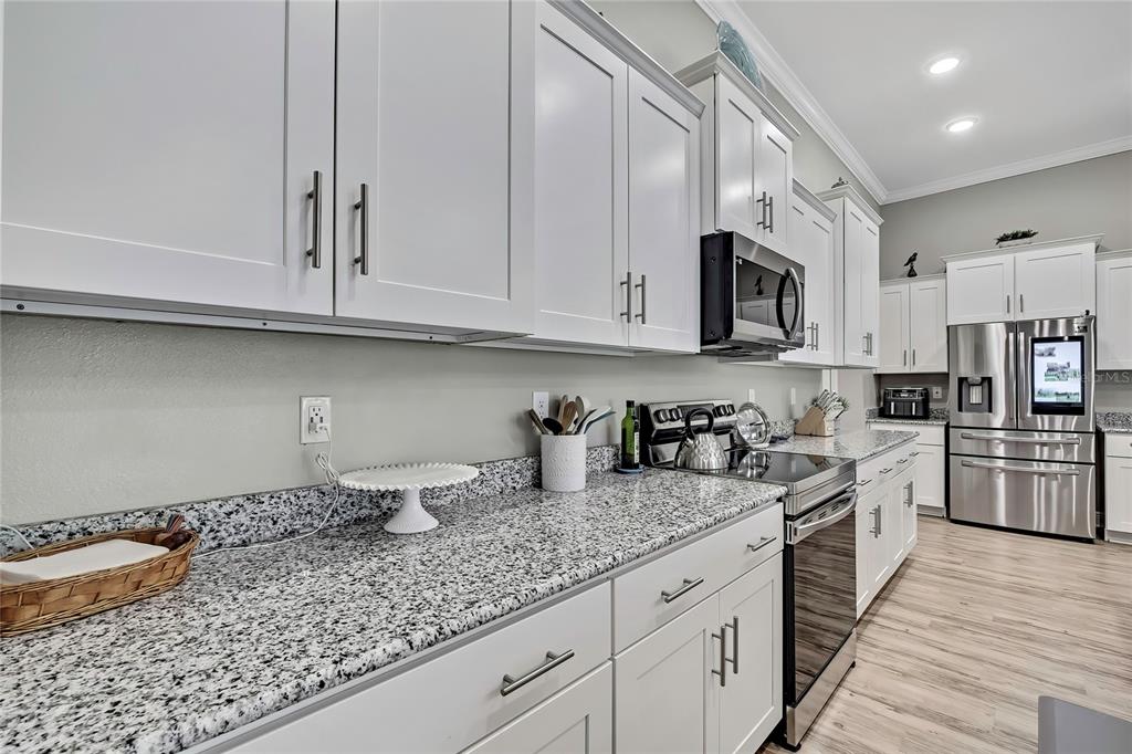 9504 Earthwind Court Weeki Wachee, FL 34613 - Photo 17 of 48 a kitchen with stainless steel appliances granite countertop a sink a stove and cabinets