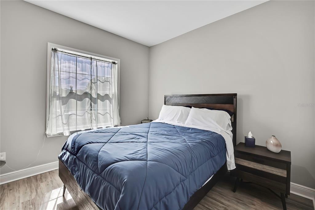 9504 Earthwind Court Weeki Wachee, FL 34613 - Photo 19 of 48 a bedroom with a bed and wooden floor