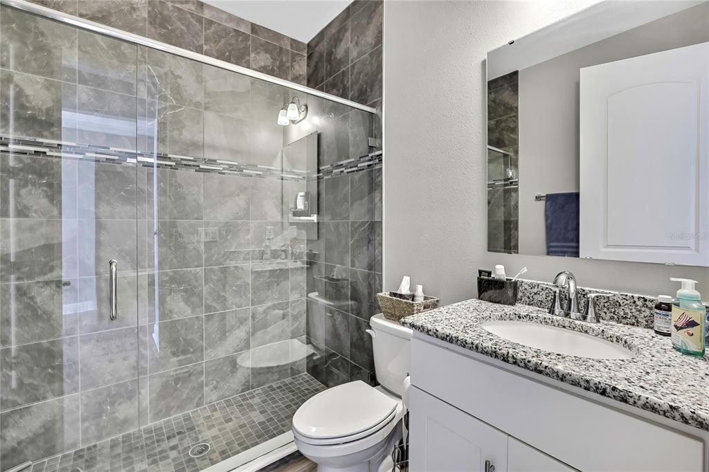 9504 Earthwind Court Weeki Wachee, FL 34613 - Photo 20 of 48 a bathroom with a granite countertop sink a toilet and shower