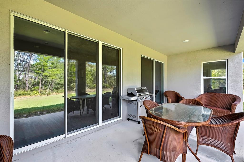 9504 Earthwind Court Weeki Wachee, FL 34613 - Photo 38 of 48 a dining room with furniture and a floor to ceiling window