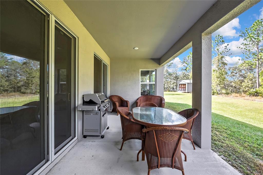 9504 Earthwind Court Weeki Wachee, FL 34613 - Photo 39 of 48 a dining room with furniture and a floor to ceiling window