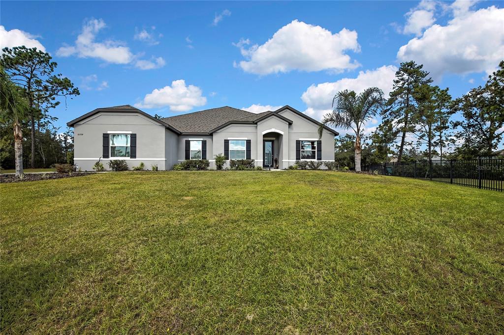 9504 Earthwind Court Weeki Wachee, FL 34613 - Photo 45 of 48 a white house with a big yard and large trees