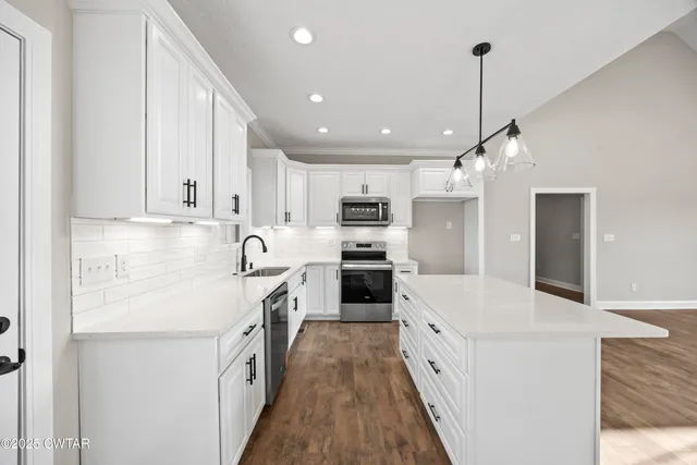 a large kitchen with stainless steel appliances sink a microwave and cabinets