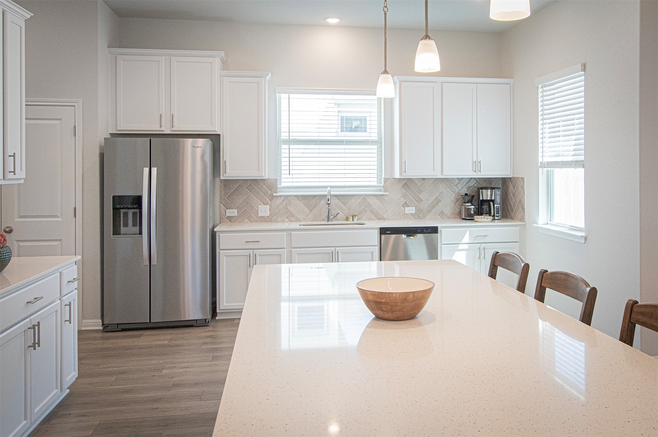 249 Treadwell Lane Kyle, TX 78640 - Photo 8 of 26 a kitchen with a refrigerator a sink dishwasher a stove and white cabinets with wooden floor