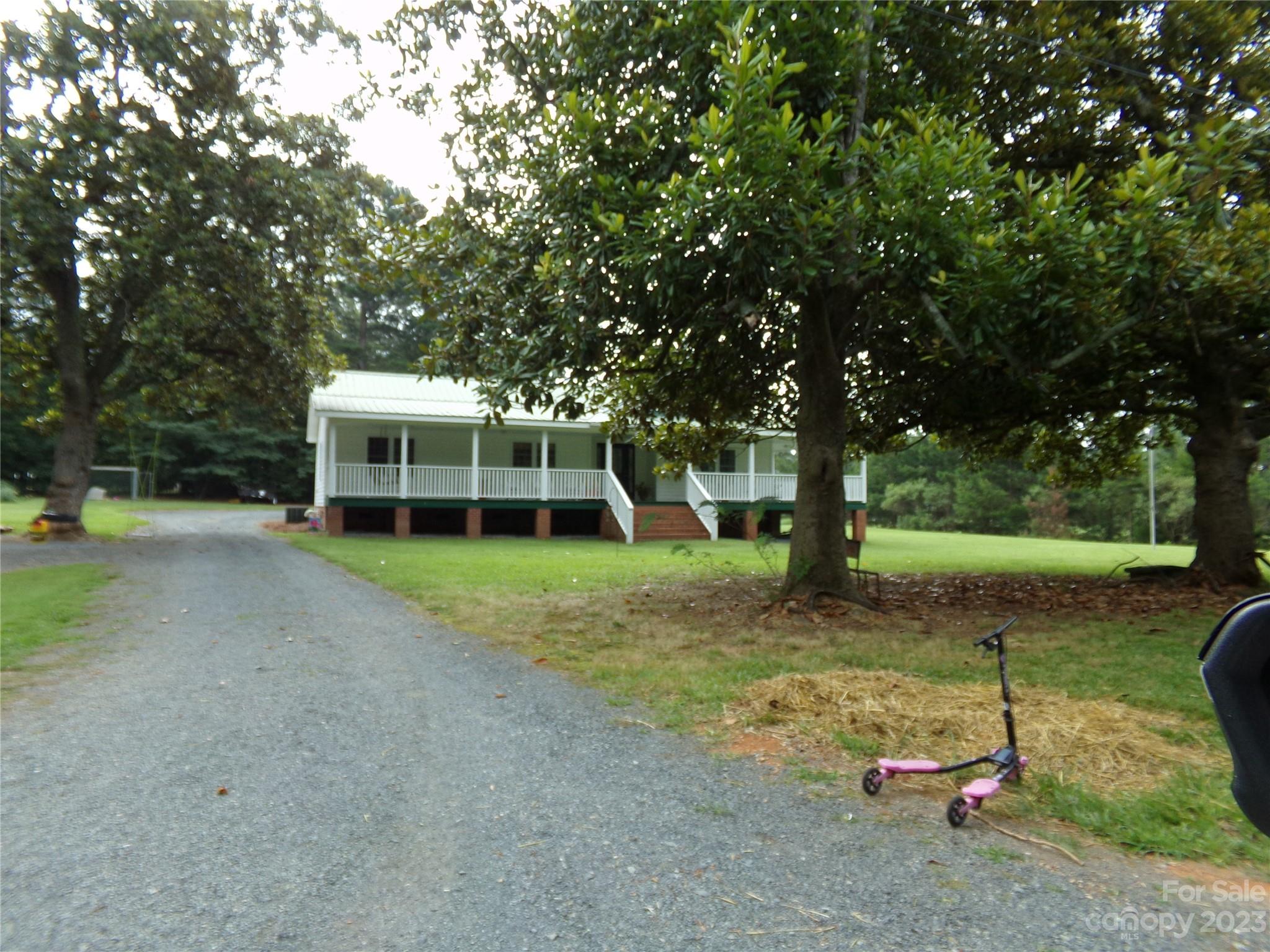 109 Tucker Street Locust, NC 28097 - Photo 4 of 13 a view of a house with backyard and a tree