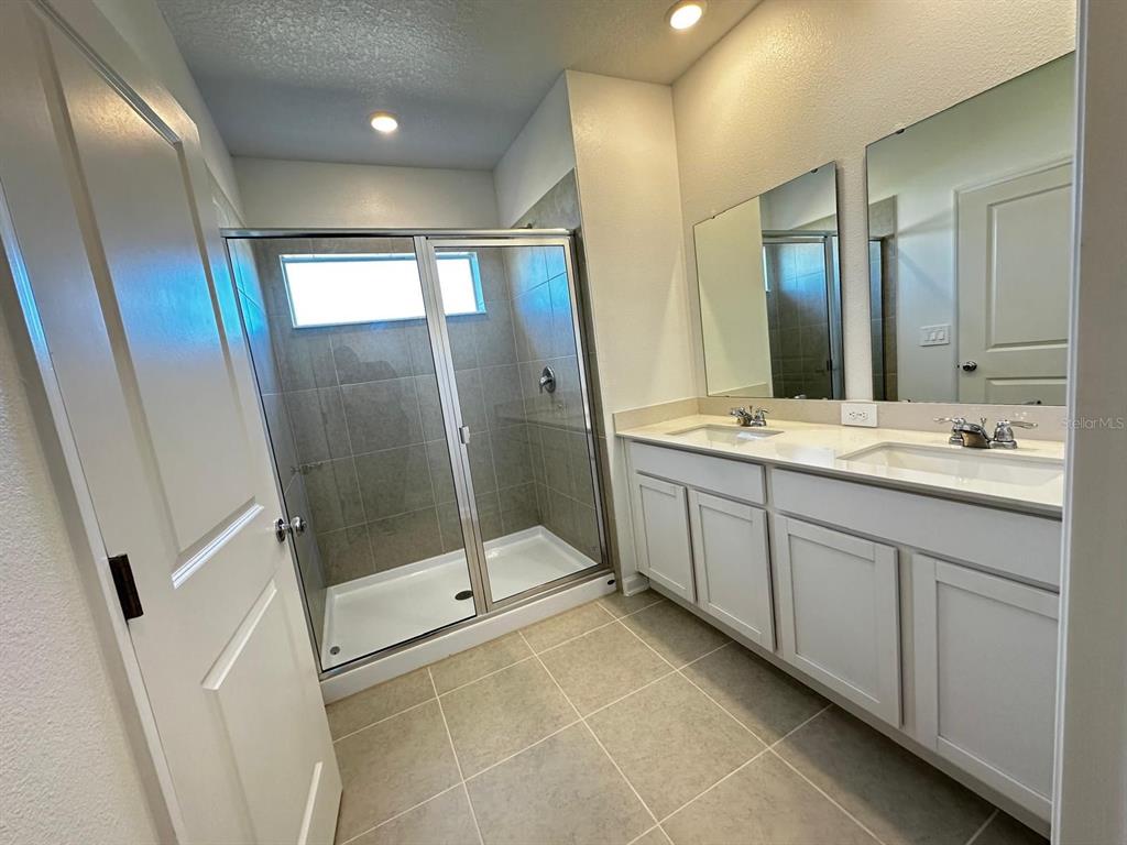 2713 Skyline Loop Kissimmee, FL 34758 - Photo 11 of 20 a spacious bathroom with a mirror sink and shower