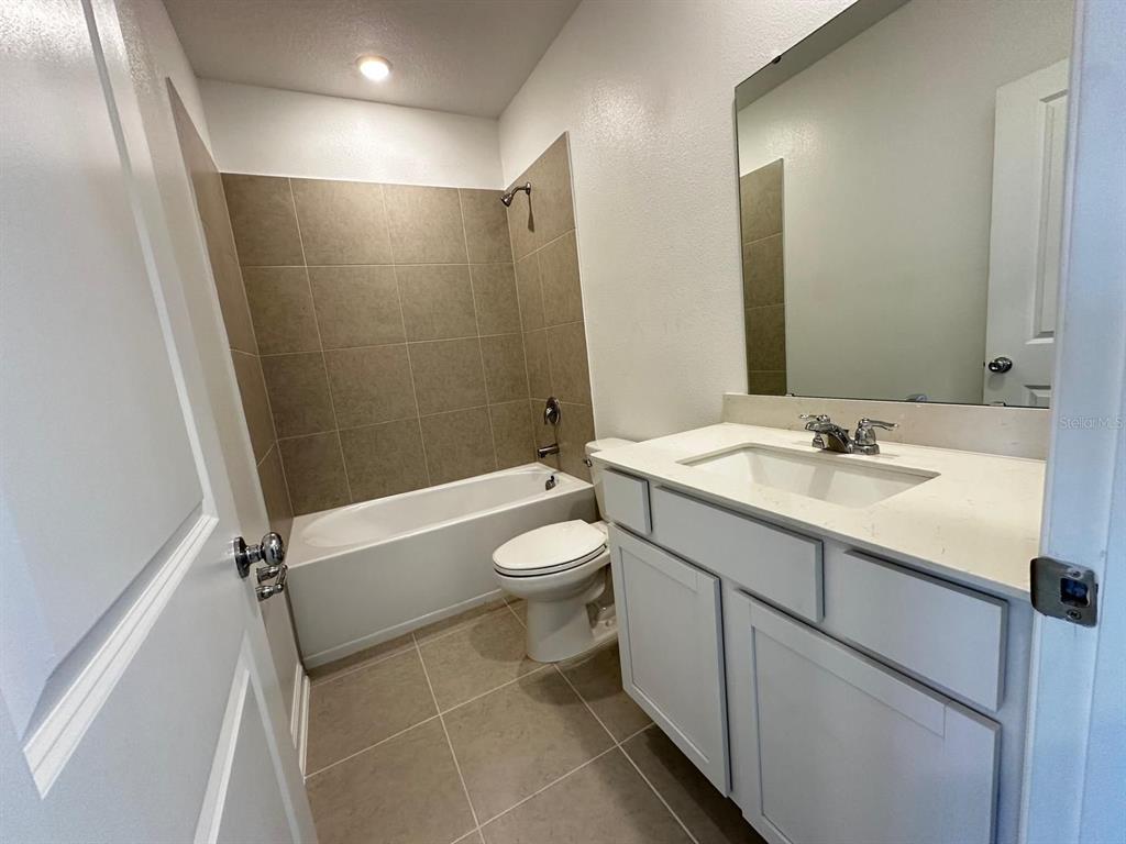 2713 Skyline Loop Kissimmee, FL 34758 - Photo 16 of 20 a bathroom with a granite countertop sink toilet and shower