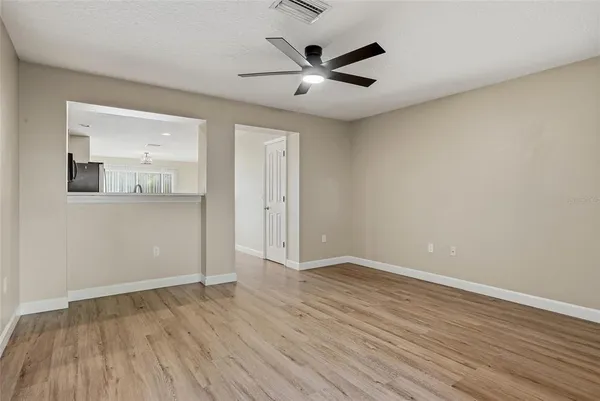 an empty room with wooden floor and windows