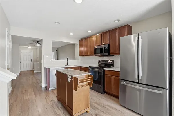 a kitchen with stainless steel appliances granite countertop a refrigerator stove and sink