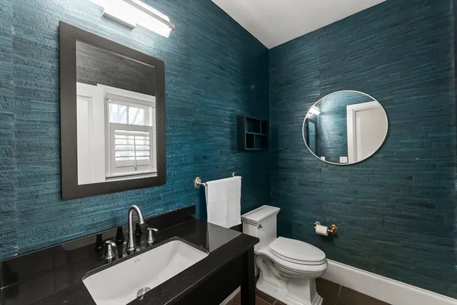 a bathroom with a toilet a sink and mirror