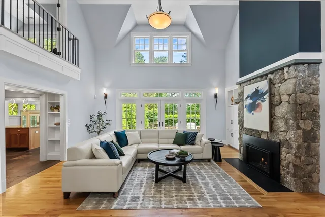 a living room with furniture a fireplace and a floor to ceiling window